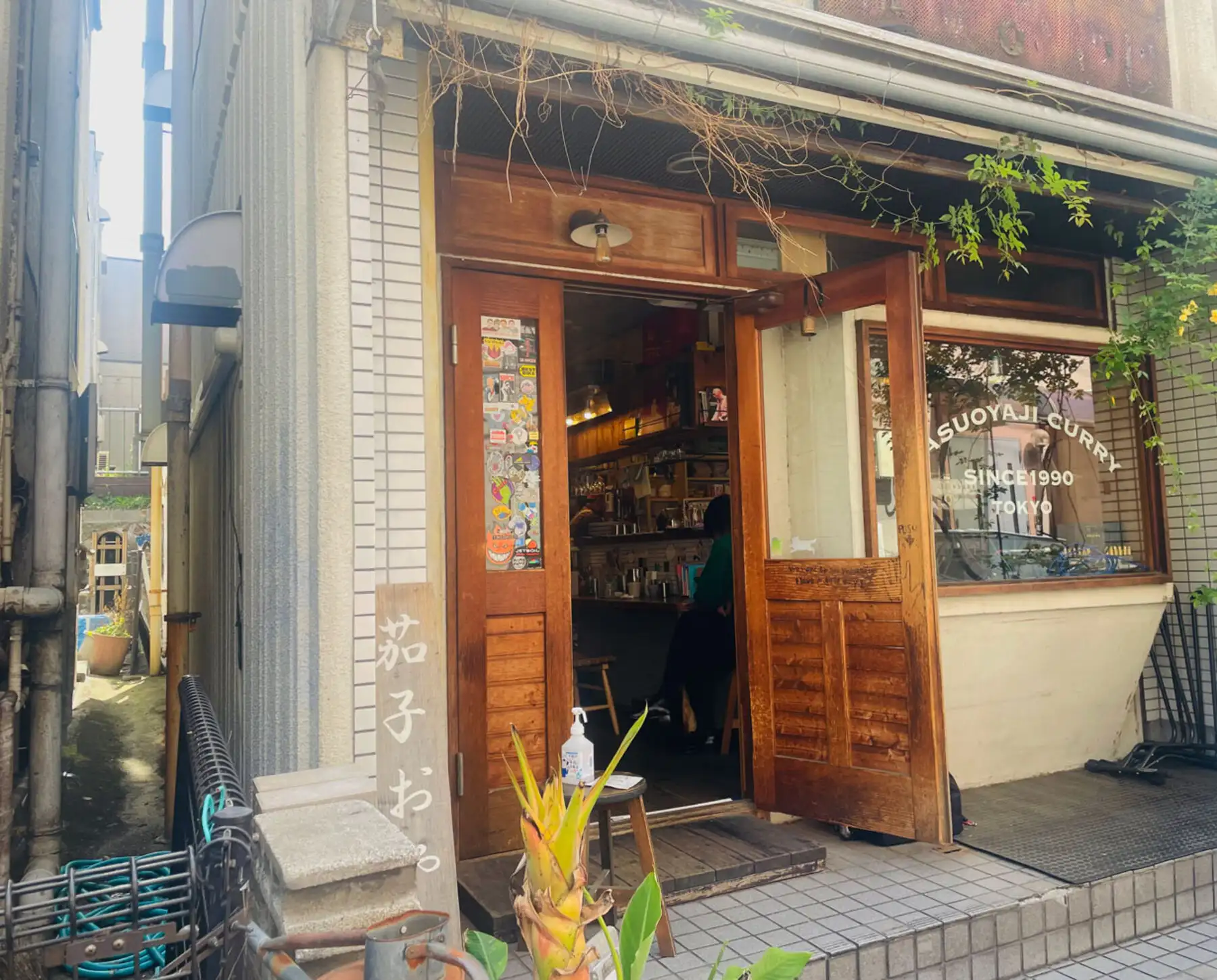 木の扉を開け放った茄子おやじの店先。窓ガラスに SINCE 1990 の白い文字