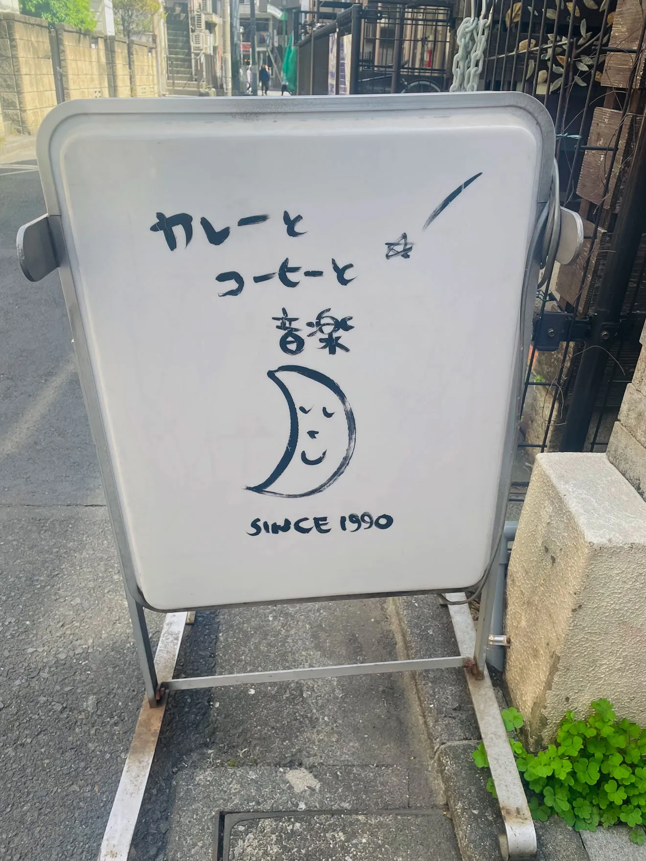 店頭の立て看板。手書きで「カレーと コーヒーと 音楽 SINCE 1990」
